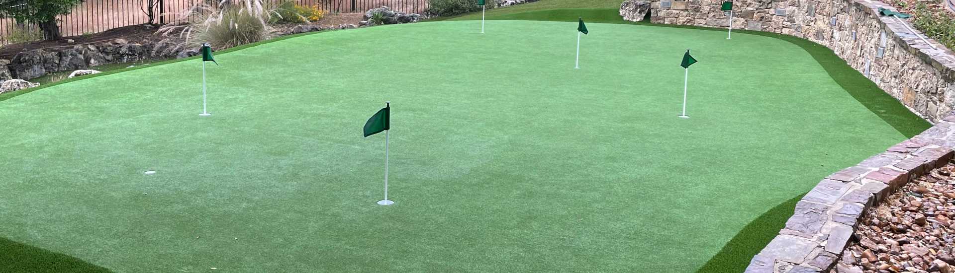 Artificial grass backyard putting green installed by Southwest Greens, featuring smooth turf, multiple golf holes, and a low-maintenance landscape design for year-round play.